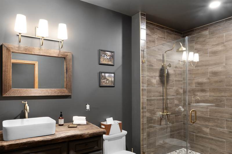 A bathroom with a live-edge vanity and a glassed walk-in shower