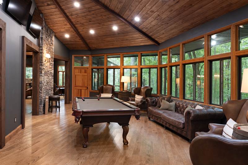 A billiards table in a room glazed on three sides
