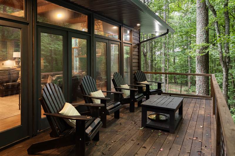 Adirondack chairs on the lodge deck looking into timber