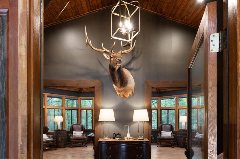 The lodge entry hall with a vaulted plank ceiling and an elk mount