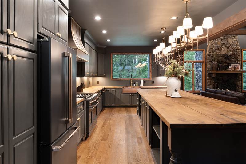 The lodge kitchen with charcoal cabinetry and a butcher-block island
