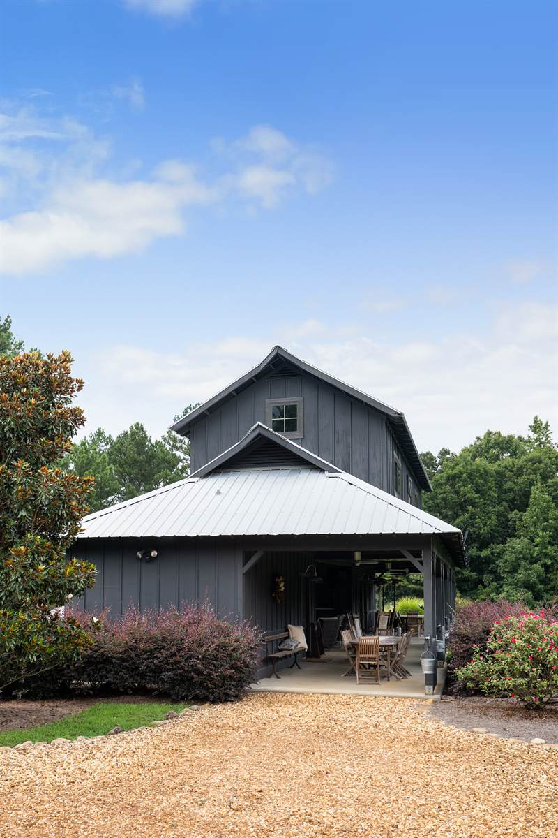 The gable end of the black board-and-batten pavilion