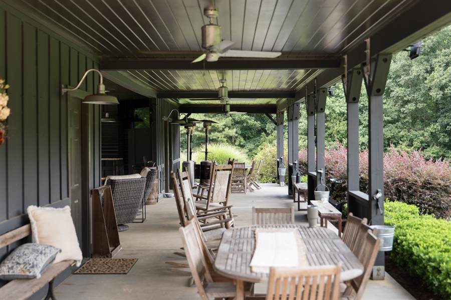 The covered porch lined with rocking chairs and long tables